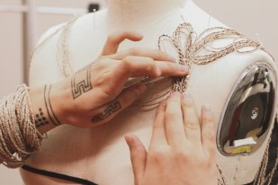 Meghann O’Brien manipulating strings on a mannequin—the form may become a necklace and may be incorporated into the structure of a garment, photograph by Neebinnaukzhik Southall